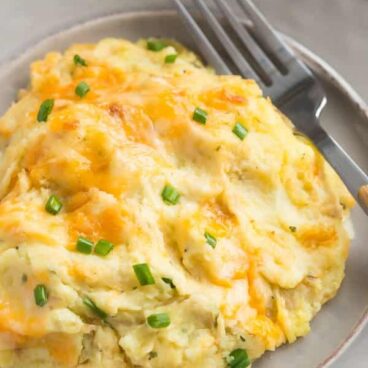 These Cheesy Make Ahead Mashed Potatoes are so creamy and perfect for the holidays! No more rushing around before Christmas dinner -- simply reheat and serve! Includes step by step recipe video. | make ahead meal | meal prep | cheesy mashed potatoes | cream cheese mashed potatoes | Christmas | Thanksgiving | Easter | holiday dinner