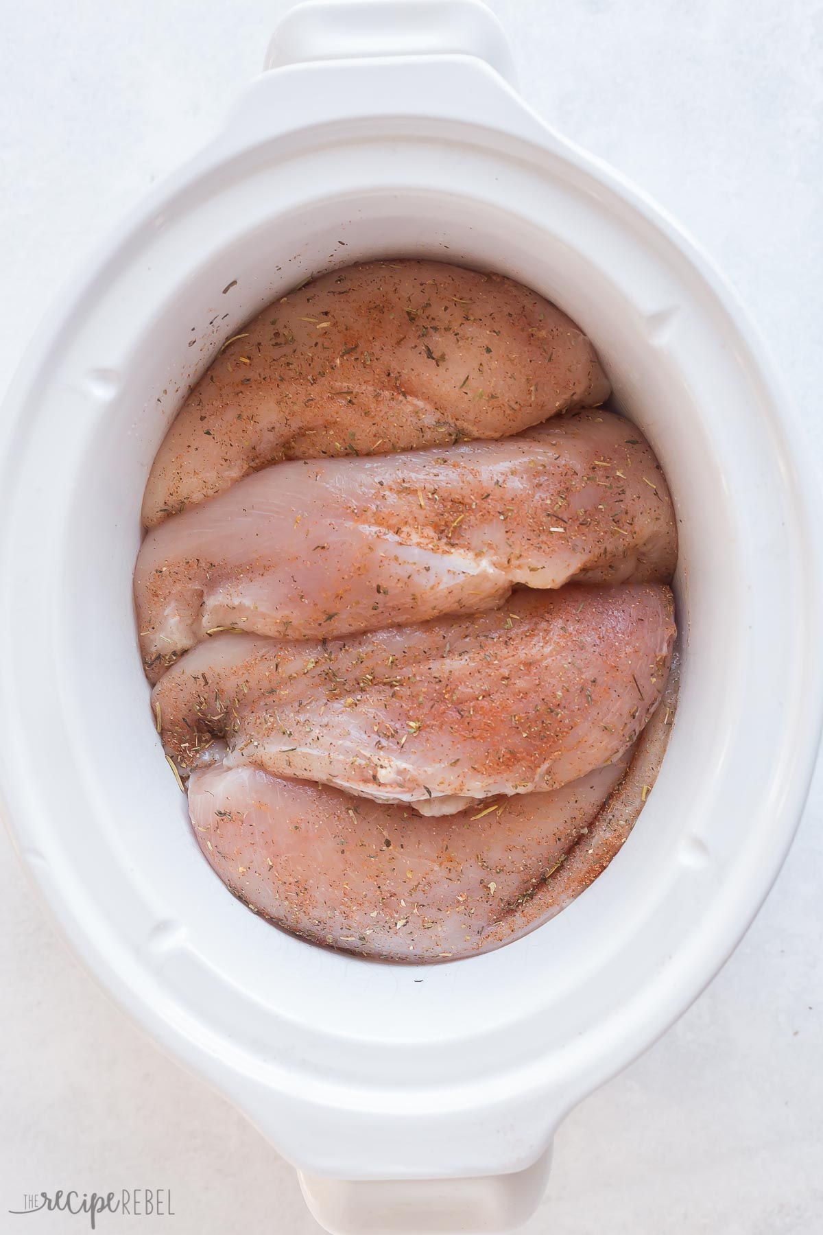 seasoned chicken breasts placed in slow cooker