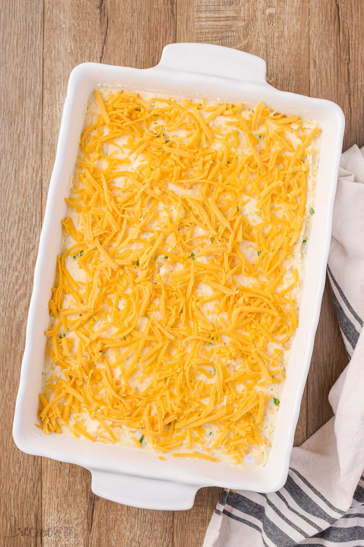 shredded cheddar cheese on top of pan of mashed potatoes