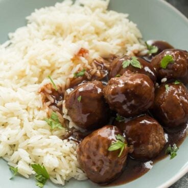 These Slow Cooker Cranberry Meatballs are sweet and tangy with a little spice -- the perfect holiday appetizer or easy weeknight dinner! Includes step by step recipe video | slow cooker recipe | crockpot recipe | crock pot | dinner | easy recipe | Christmas | thanksgiving | game day | football | party food | #slowcookerrecipes