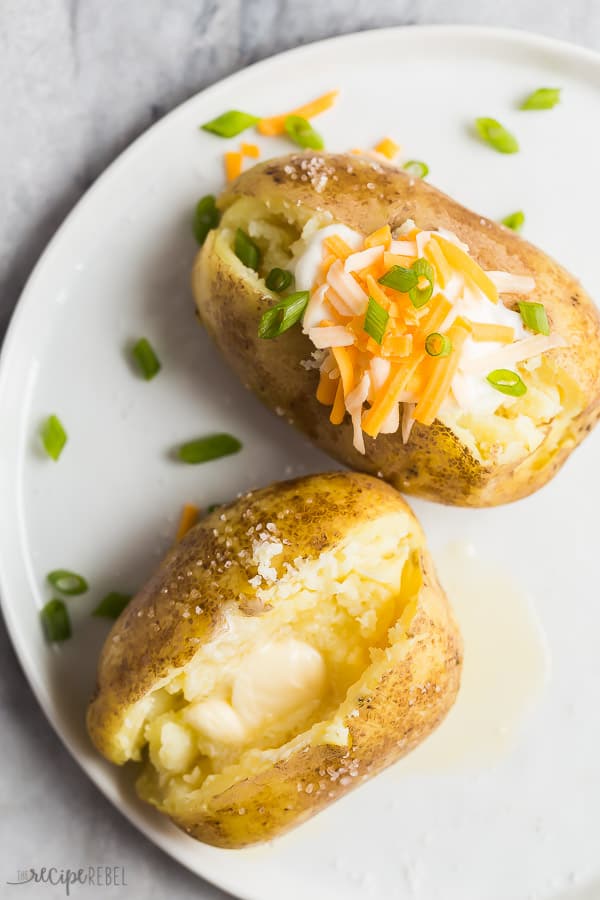 instant pot baked potatoes on plate overhead with butter sour cream and shredded cheese