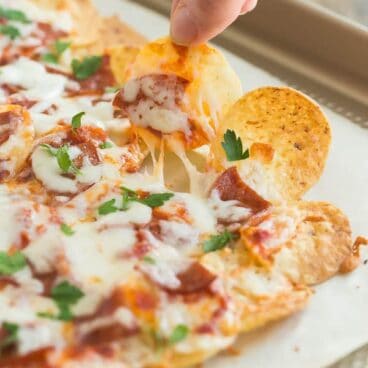 I'll show you how to make the best nachos and 3 different ways to do them up! Nachos are a crowd favourite every Super Bowl, game day or family movie night -- an easy appetizer or easy dinner that everyone loves! Skip the regular ground beef in favour of these Pepperoni Pizza, Philly Cheesesteak, or Bacon Chicken Alfredo nachos. #nachos #gameday #superbowl #appetizer #recipe
