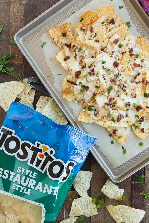 overhead image of chicken alfredo nachos with bacon on sheet pan with tostitos on the side