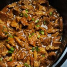 black crockpot full of bourbon chicken