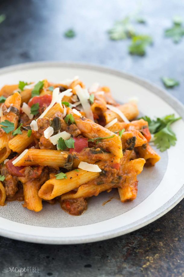 plate of Instant Pot baked ziti on grey background with fresh parsley