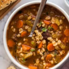 overhead image of beef barley soup with spoon in bowl