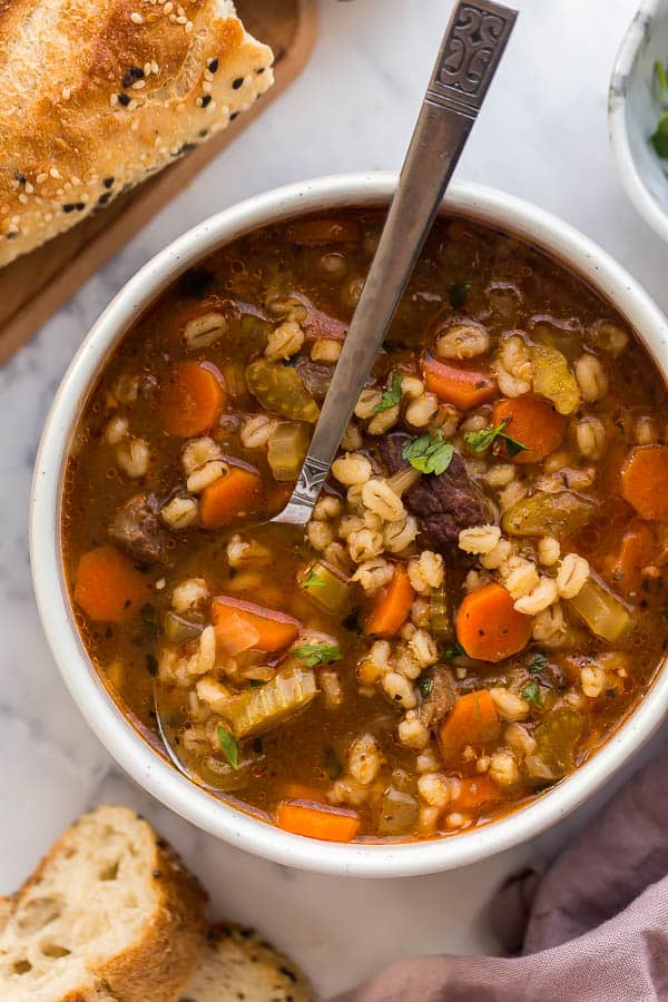 overhead image of beef barley soup with spoon in bowl