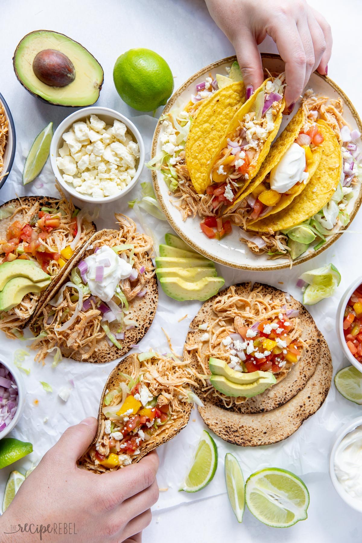 overhead image of crockpot chicken tacos and toppings in bowls