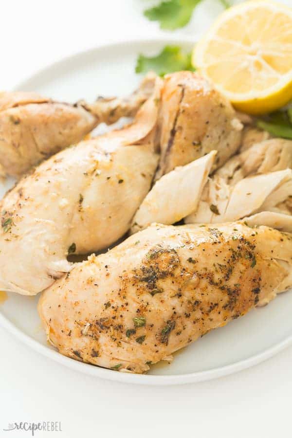 This Instant Pot Whole Chicken recipe can be made with fresh or frozen chicken! It is moist, juicy and so much easier than roasting! Slathered in garlic butter and cooked to perfect in your pressure cooker in just 30 minutes. | Instant Pot Pressure Cooker Whole Chicken on a white plate