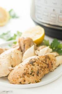 Instant Pot Whole Chicken on a white plate |This Instant Pot Whole Chicken recipe can be made with fresh or frozen chicken! It is moist, juicy and so much easier than roasting! Slathered in garlic butter and cooked to perfect in your pressure cooker in just 30 minutes.