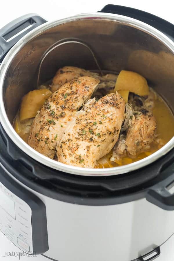 whole chicken cooked in instant pot on trivet with lemon halves