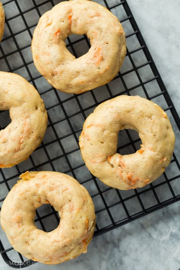 carrot cake donuts no frosting on black cooling rack on marble