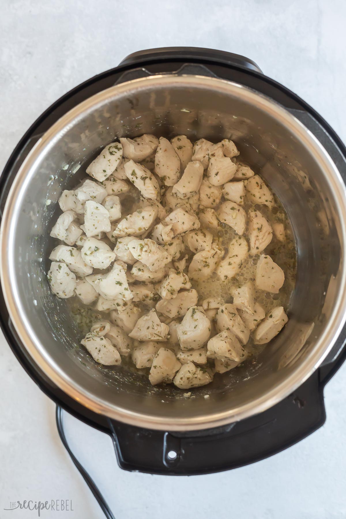 seasoned chicken breast pieces cooking in instant pot.
