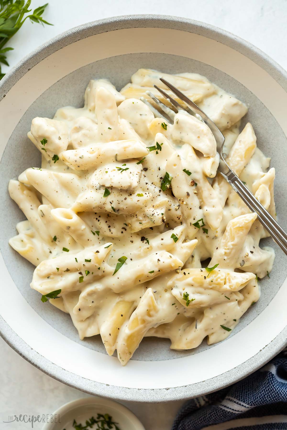 overhead image of instant pot chicken alfredo in grey bowl with fork.