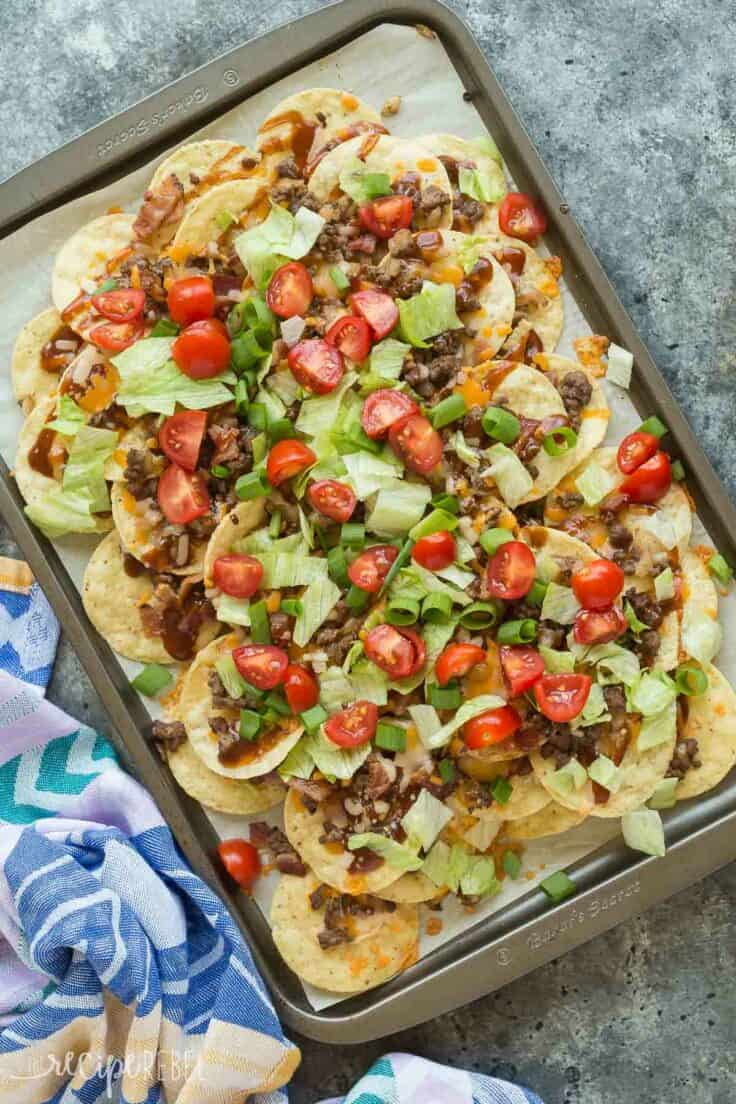 bbq bacon cheeseburger nachos overhead on sheet pan on grey background