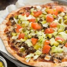 This Grilled Cheeseburger Pizza is an easy summer meal idea! The pizza dough comes together in just 10 minutes and cooks in 6 minutes on the grill! A quick dinner recipe for any night of the week, loaded with all your favourite cheeseburger toppings.