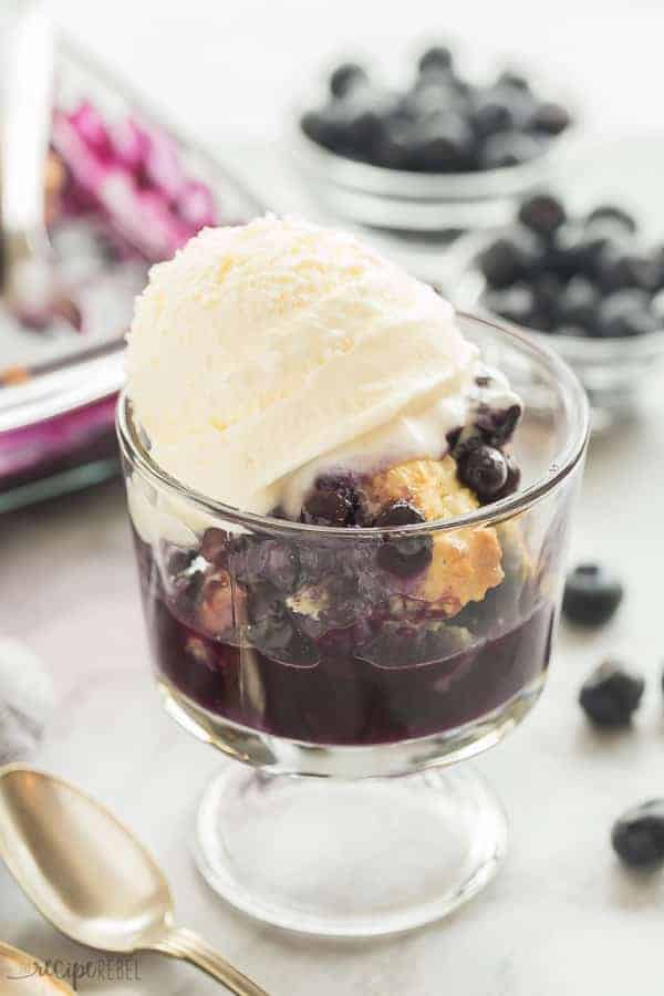 blueberry cobbler in a glass dish with ice cream