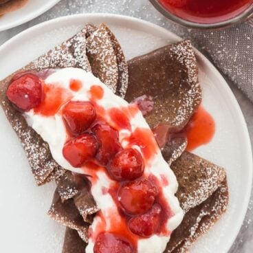 chocolate crepes with whipped cream and strawberry sauce