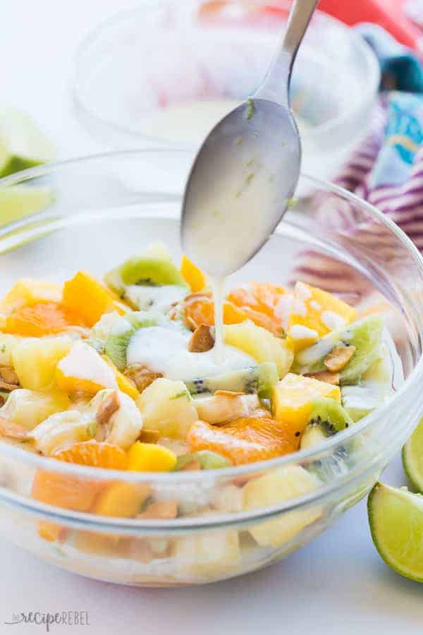 hawaiian fruit salad with spoon drizzling dressing on top