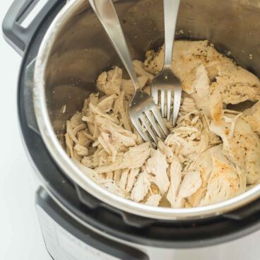 shredded chicken with two forks in instant pot.