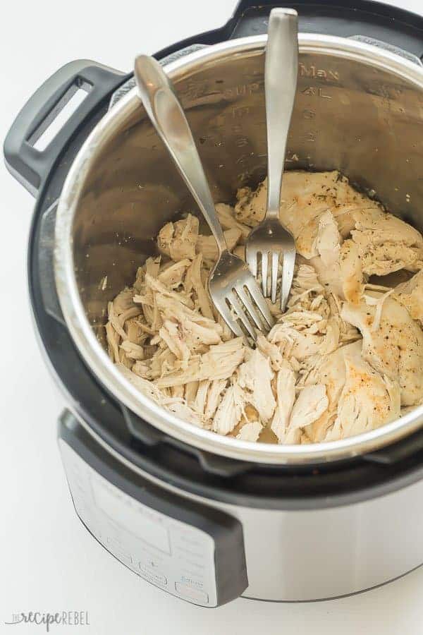 instant pot shredded chicken in pressure cooker with two forks stuck in chicken