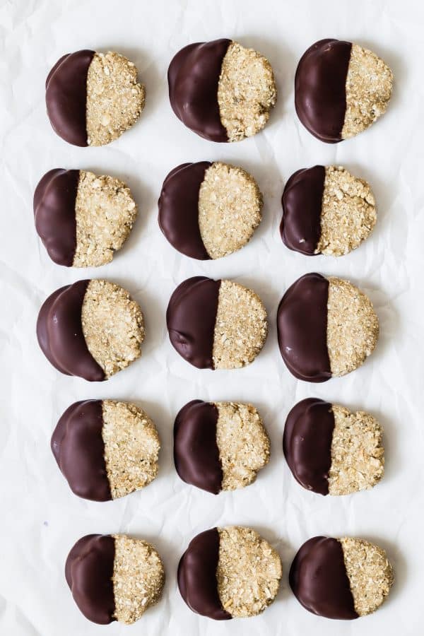 no bake coconut lime cookies overhead in rows with half of cookie dunked in chocolate