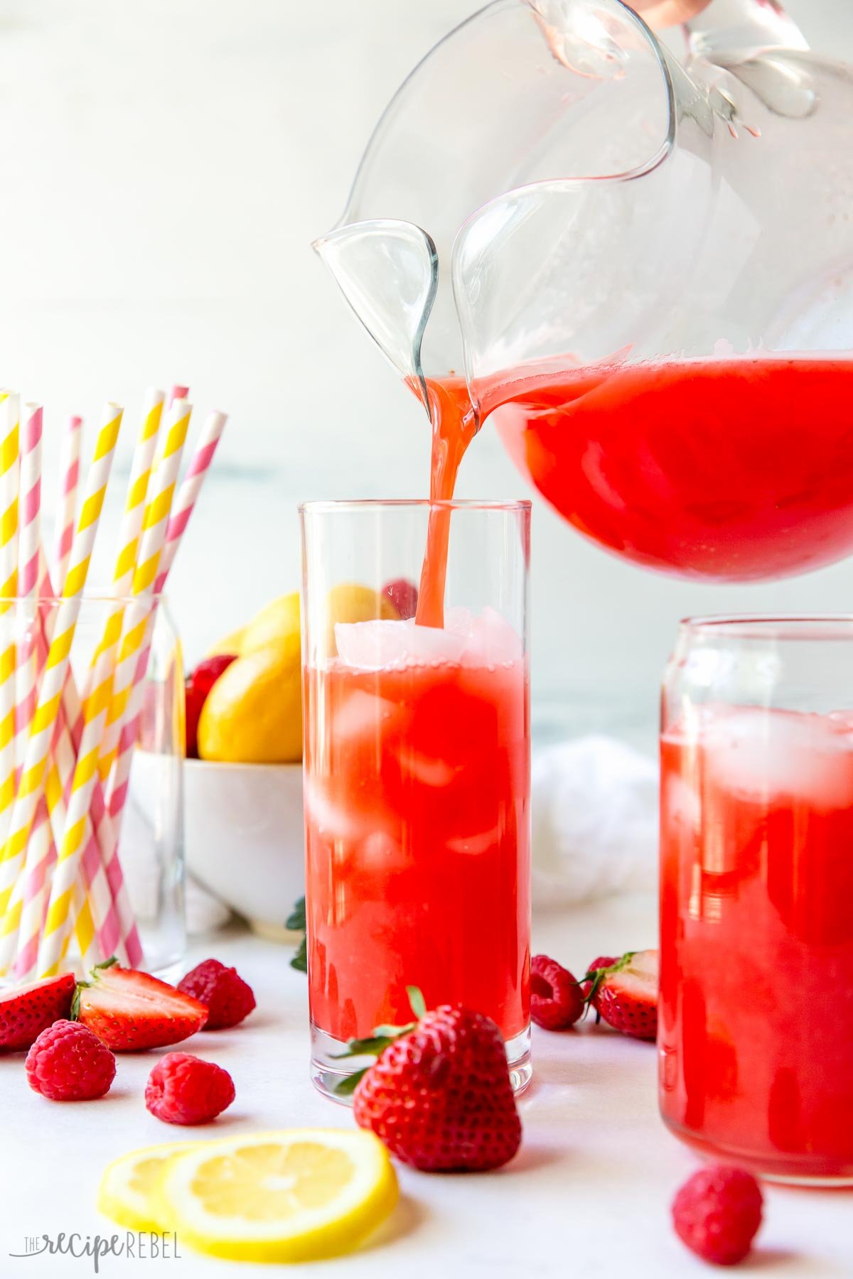 pouring pink lemonade into a tall glass