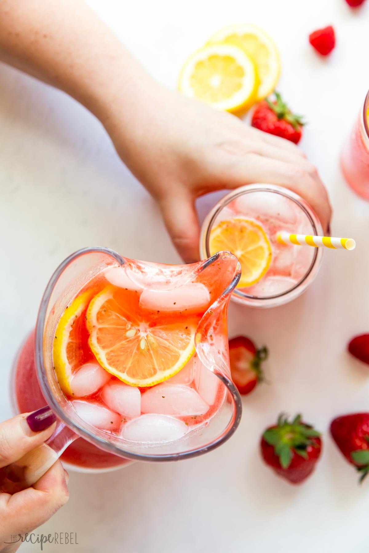 pouring pink lemonade from pitcher into glass