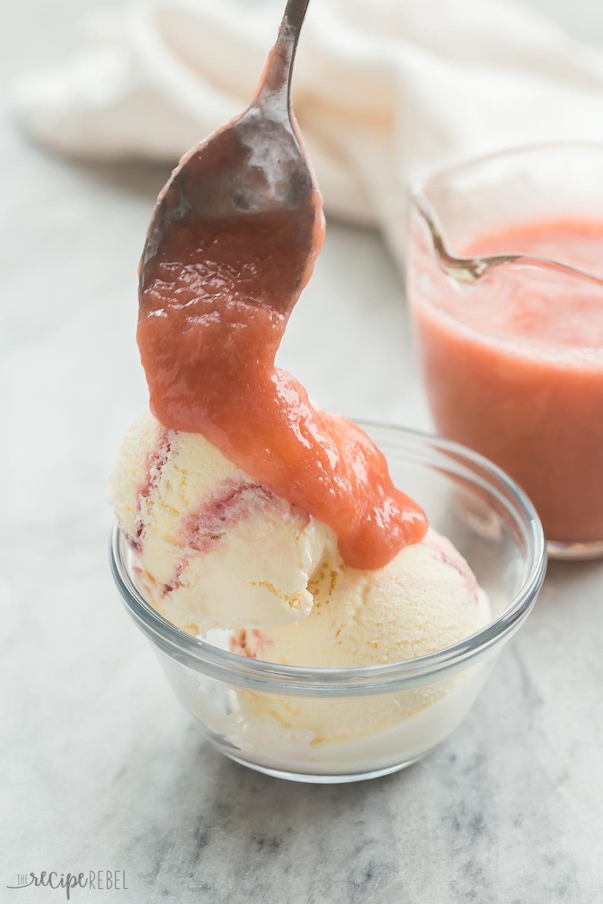 This Rhubarb Sauce Recipe is a quick, easy way to make the most of that Spring rhubarb! It's tart and sweet and perfect over ice cream, cake, vanilla yogurt or pancakes for breakfast. Includes variations: strawberry rhubarb sauce, blueberry, and more. With step by step RECIPE VIDEO you can follow along. #rhubarb #sauce #condiments #recipe #recipes #homemade #easyrecipe #spring #summer | rhubarb recipes | ice cream toppings | fruit sauce recipes | spring dessert spoon pouring rhubarb sauce over ice cream.