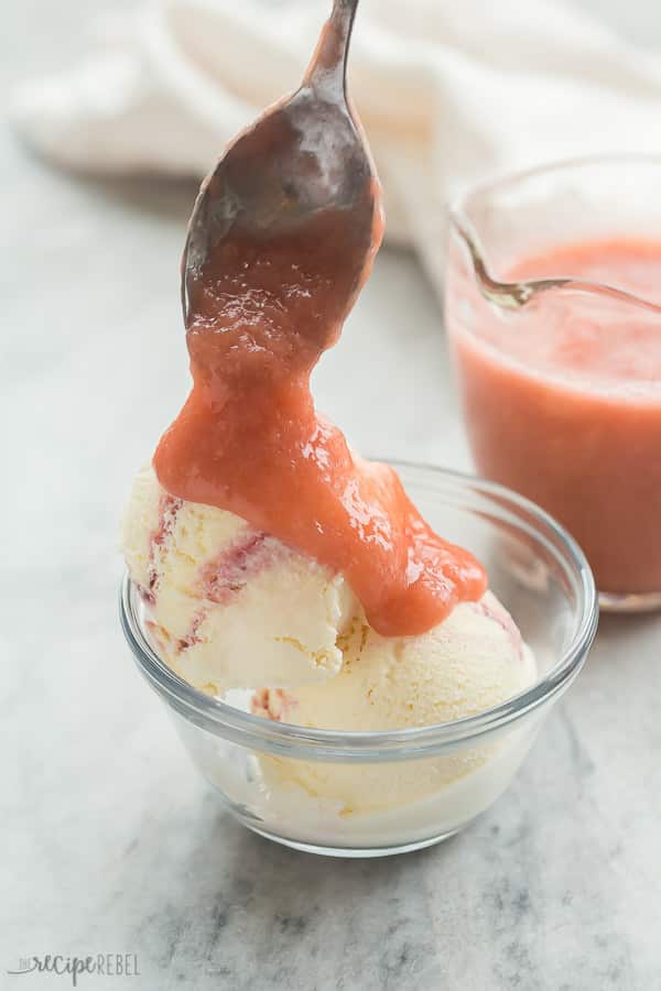 rhubarb sauce being drizzled over ice cream in glass bowl