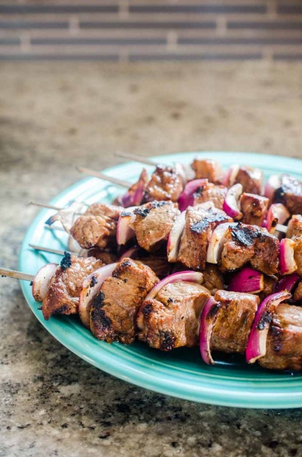 balsamic beef kabobs on blue plate on grey background