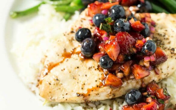grilled chicken with berry salsa on plate with green beans.