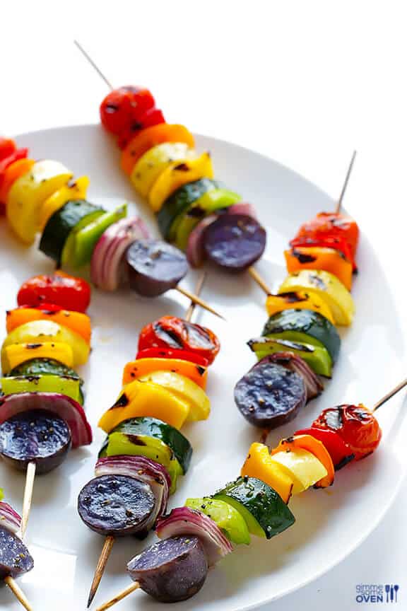 rainbow vegetable skewers on white plate on white background