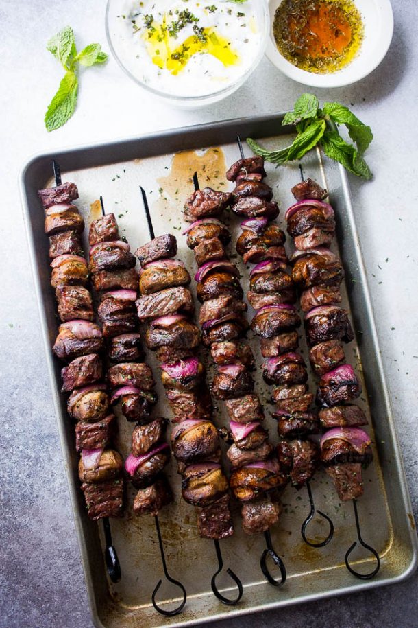 All kinds of kabob recipes for summer grilling! Chicken kabobs, shrimp kabobs, steak kabobs, and dessert kabobs! Because food on a stick is more fun ;) steak mushroom kabobs with mint yogurt dip on a sheet pan with fresh mint leaves