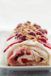 cherry cheesecake roll whole on a white plate