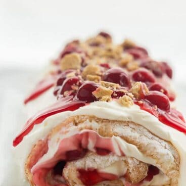 cherry cheesecake roll whole on a white plate