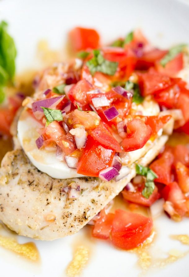 grilled chicken caprese up close with fresh chopped tomatoes and red onions