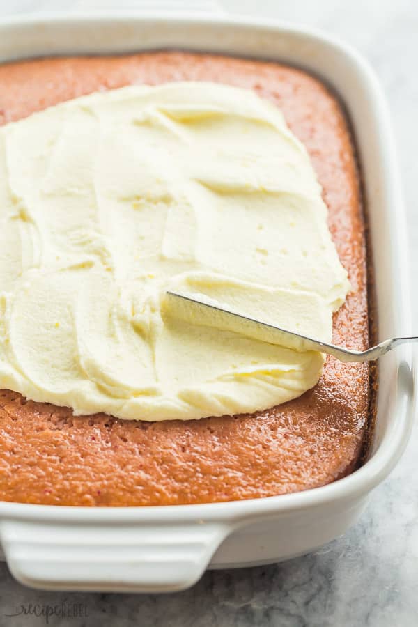 lemon frosting on strawberry cake in white baking dish