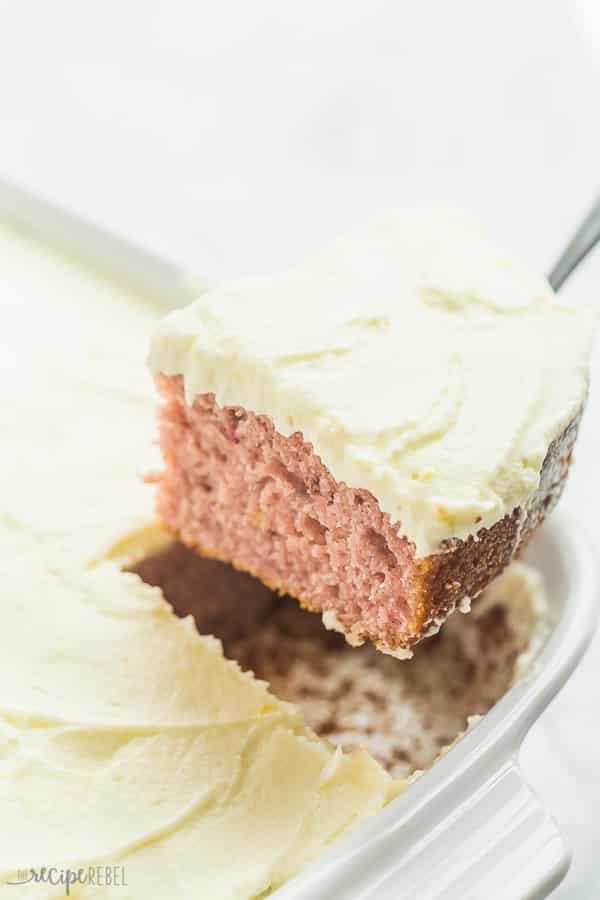 piece of strawberry lemonade cake being pulled out of white baking dish