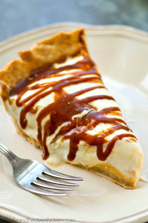 caramel pumpkin cheesecake pie with caramel drizzle on beige plate