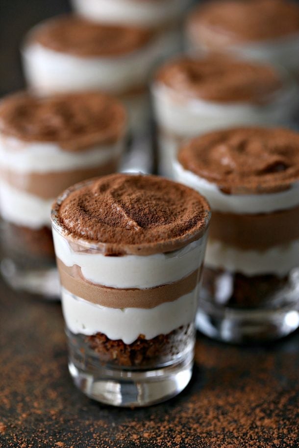 coffee chocolate cheesecake jars up close with layers of vanilla and chocolate cheesecake topped with cocoa powder