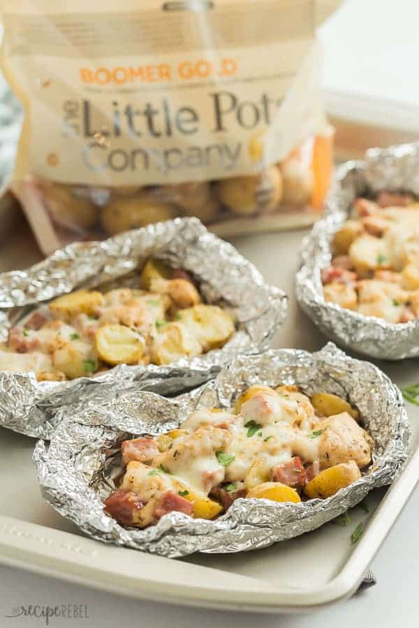 chicken cordon bleu foil packs with a bag of little potatoes in the background