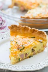 This Easy Ham Quiche recipe started with a refrigerated pie crust or you can make your own! It's filled with ham, cheese, green onions and perfectly seasoned. The perfect breakfast, dinner, or holiday brunch item! #eggs #breakfast #brunch #ham #dinner #recipe