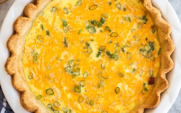 overhead image of whole ham quiche on marble background