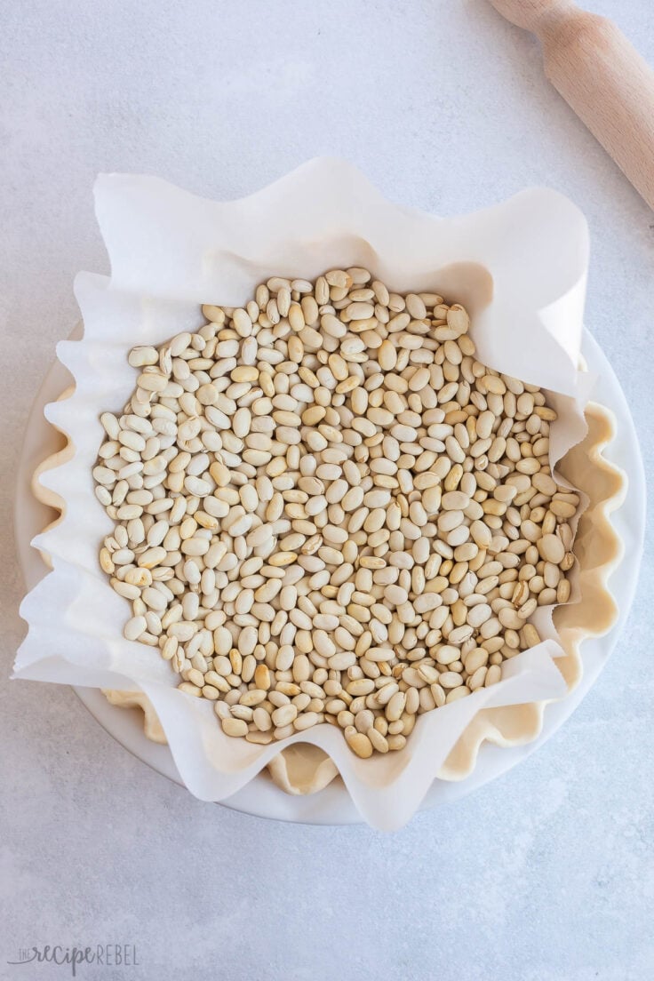 parchment and dried beans in unbaked pie crust for blind baking