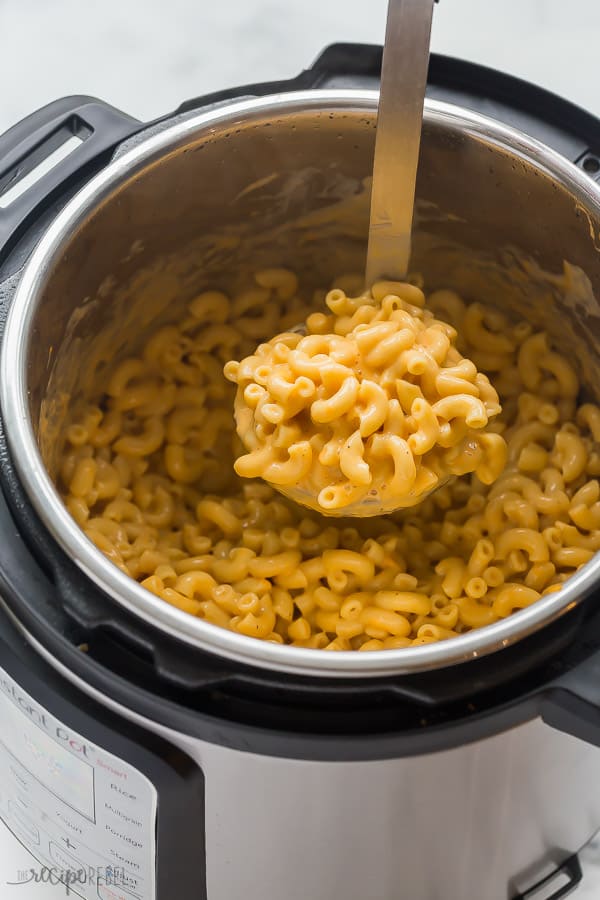 instant pot mac and cheese in pressure cooker with metal scoop scooping some out