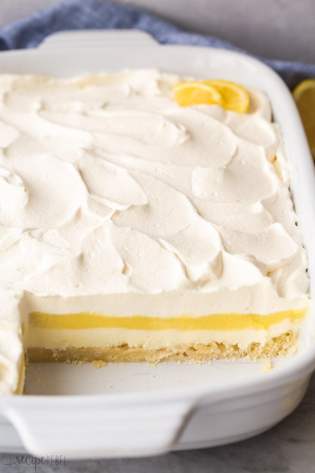 side view of lemon lush in pan with one row removed to show layers