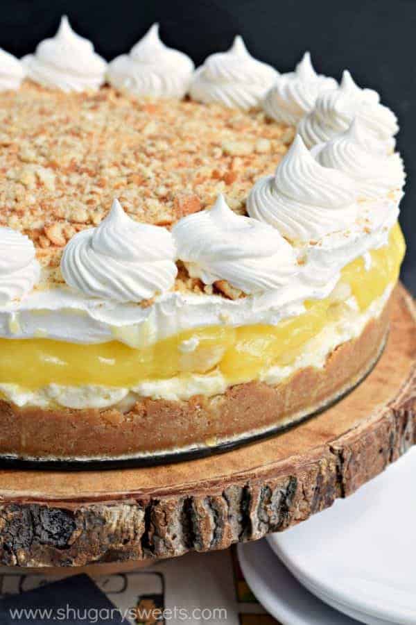 no bake banana cream cheesecake whole with whipped cream swirls and crushed wafers on top