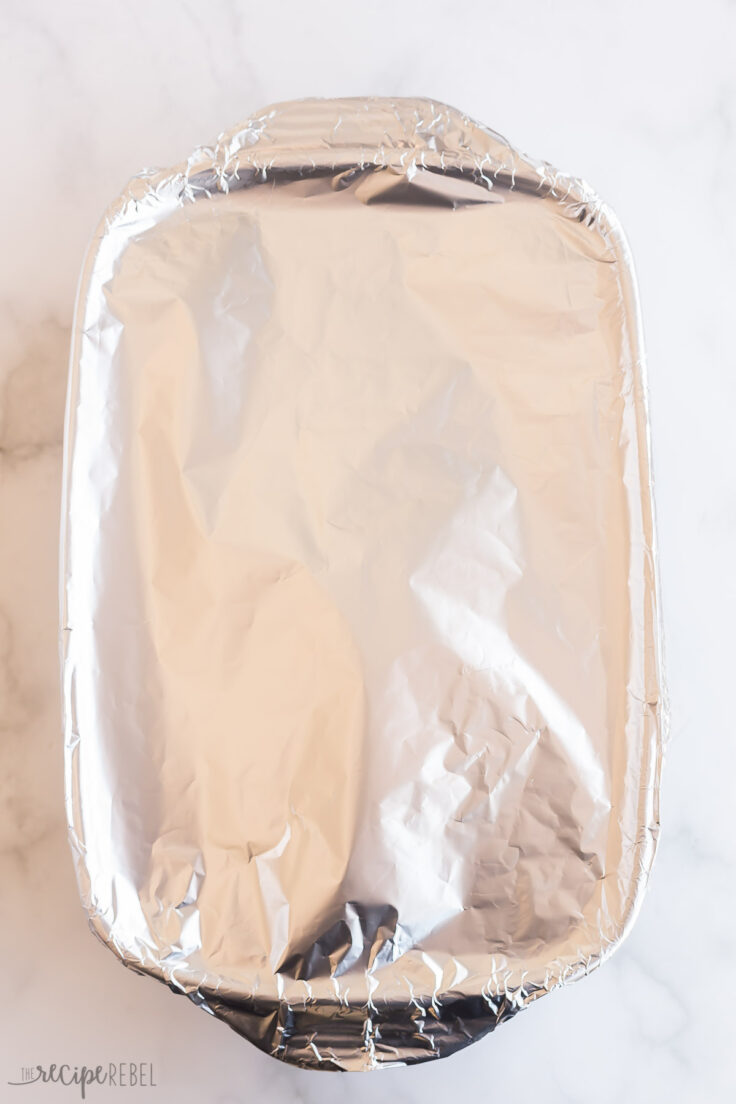 scalloped potatoes covered with foil and ready to bake