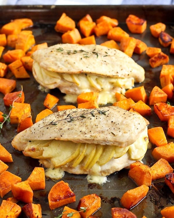 apple gouda stuffed chicken breasts on a sheet pan with roasted sweet potatoes